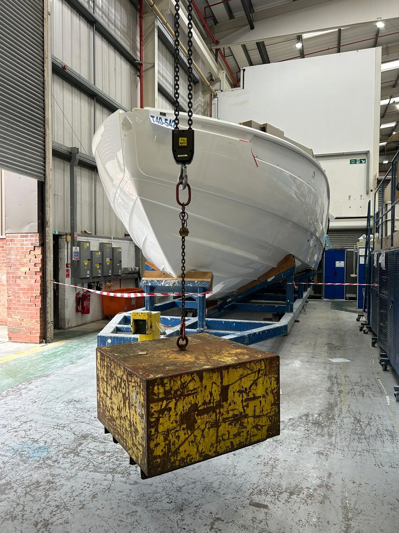 Custom lifting beam supporting a boat hull and test weight