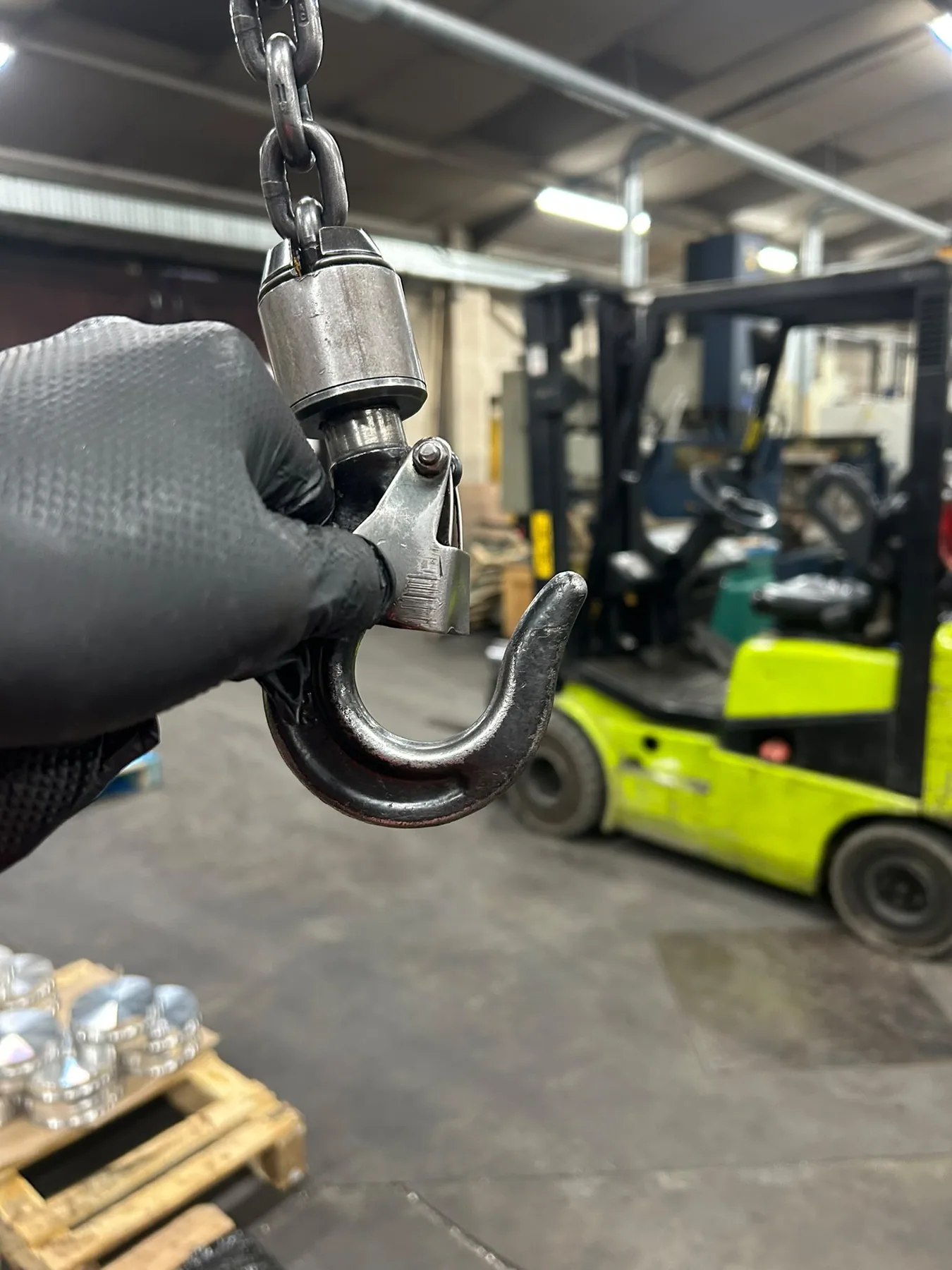 Engineer checking the hook and safety latch during a lifting-equipment inspection